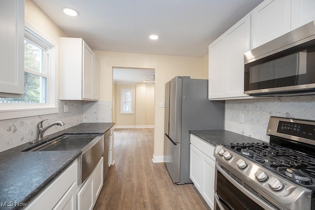 kitchen with white cabinetry, light hardwood / wood-style flooring, stainless steel appliances, and sink