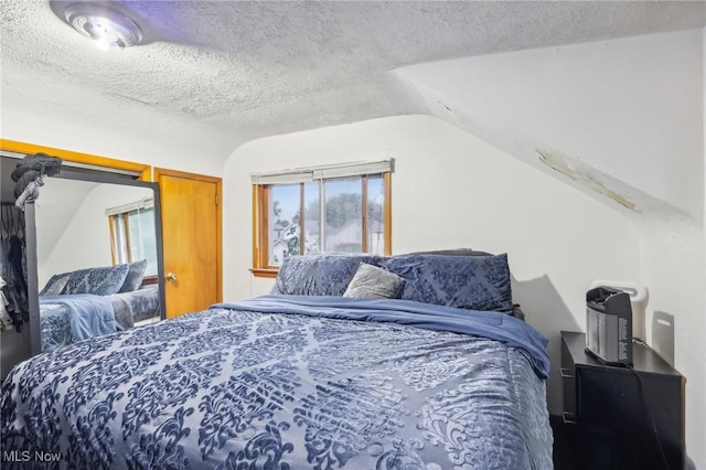 bedroom featuring a textured ceiling and vaulted ceiling