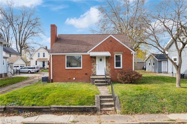 bungalow-style house featuring central AC unit and a front yard