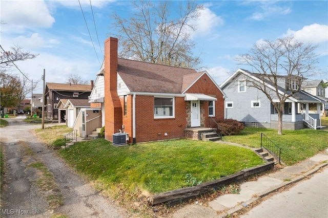 bungalow-style home with central air condition unit and a front lawn