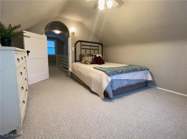 bedroom with ceiling fan, light carpet, and vaulted ceiling