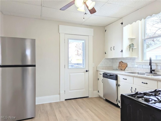 kitchen with a paneled ceiling, white cabinets, sink, and stainless steel appliances