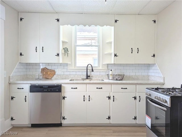 kitchen featuring a paneled ceiling, white cabinetry, sink, and appliances with stainless steel finishes