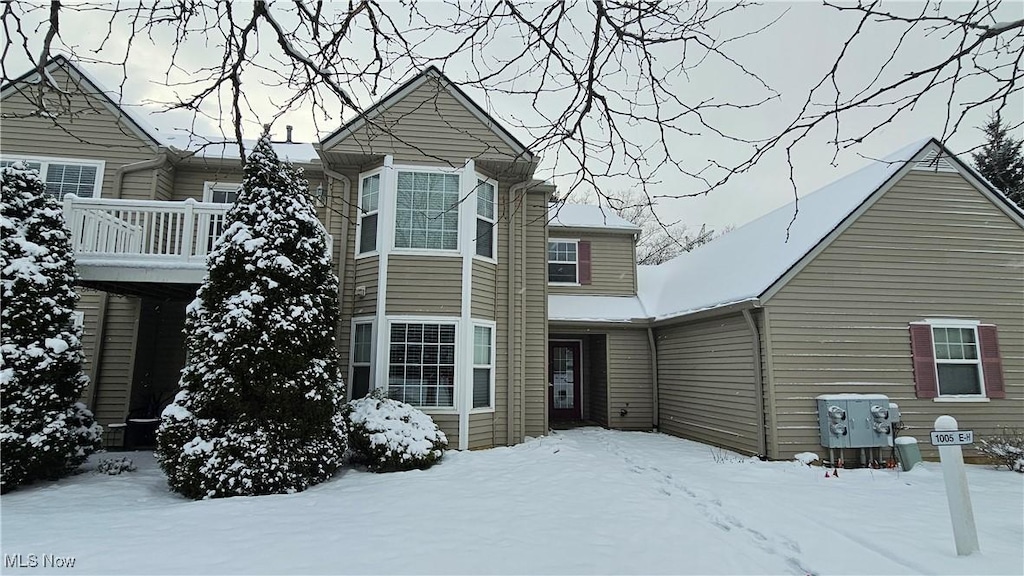 view of snow covered back of property