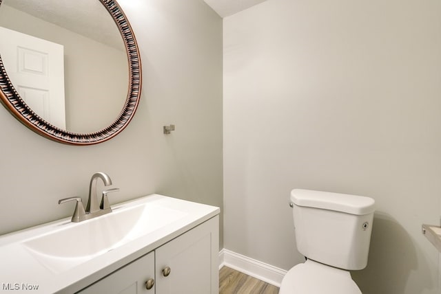 bathroom with hardwood / wood-style floors, vanity, and toilet