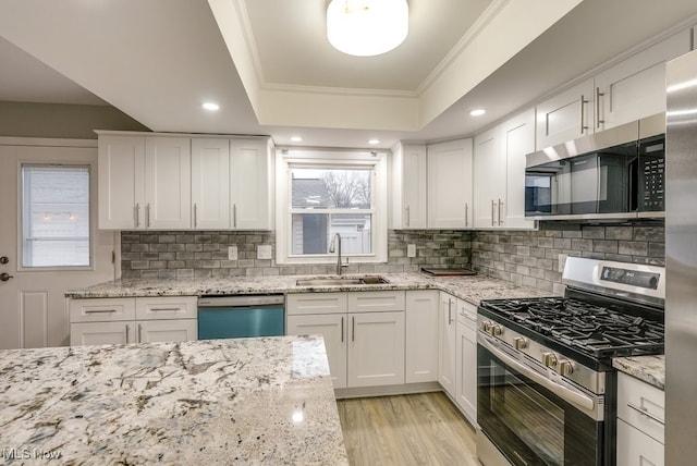 kitchen featuring crown molding, sink, white cabinetry, and stainless steel appliances