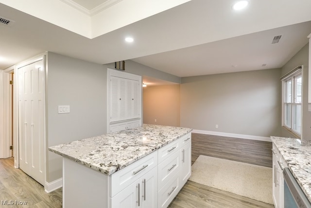 kitchen with white cabinetry, light hardwood / wood-style flooring, and light stone counters