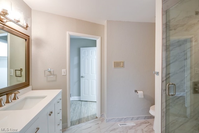 bathroom featuring vanity, an enclosed shower, and toilet