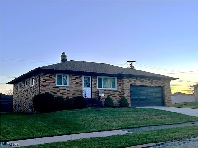 view of front of home featuring a garage and a yard