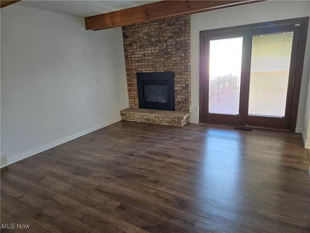 unfurnished living room with dark hardwood / wood-style floors, beam ceiling, and a fireplace