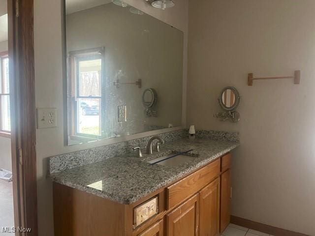 bathroom featuring tile patterned flooring, vanity, and a wealth of natural light