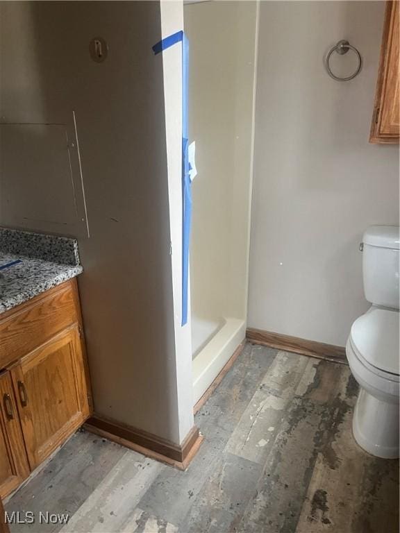 bathroom featuring vanity, toilet, and walk in shower