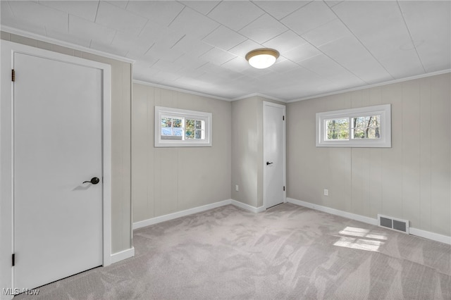 empty room featuring light carpet, plenty of natural light, and ornamental molding