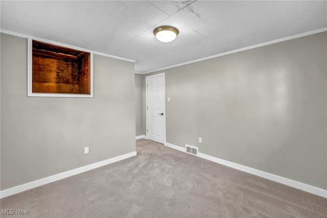 carpeted empty room featuring crown molding