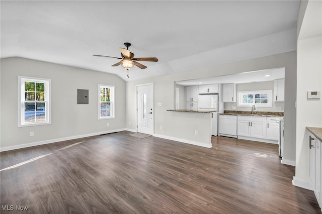 unfurnished living room featuring ceiling fan, a wealth of natural light, lofted ceiling, and electric panel