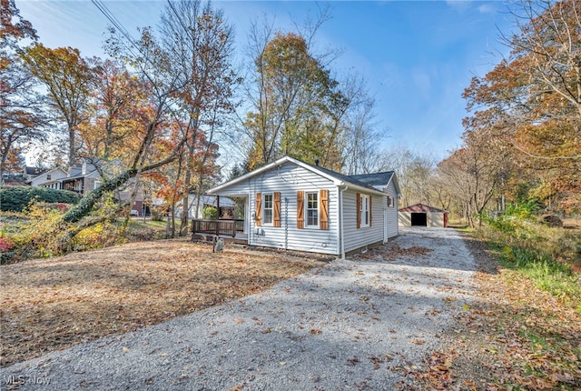 view of side of home featuring a porch, a garage, and an outdoor structure