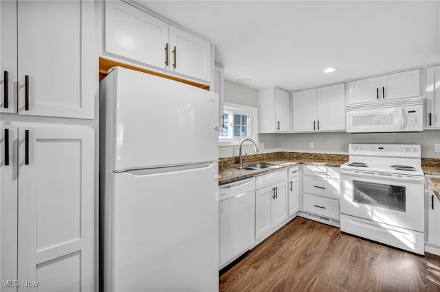 kitchen with white appliances, sink, dark stone countertops, dark hardwood / wood-style flooring, and white cabinetry