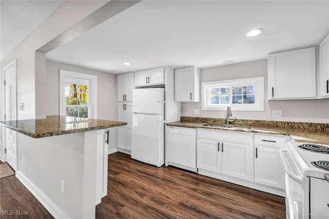 kitchen featuring white appliances, white cabinets, sink, dark hardwood / wood-style floors, and dark stone countertops