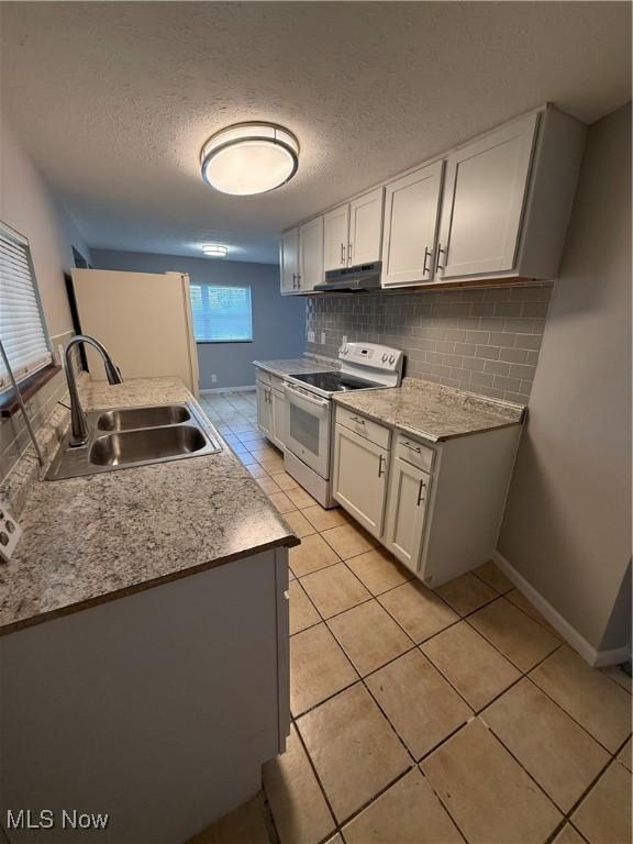 kitchen featuring white electric range oven, a textured ceiling, white cabinets, and sink