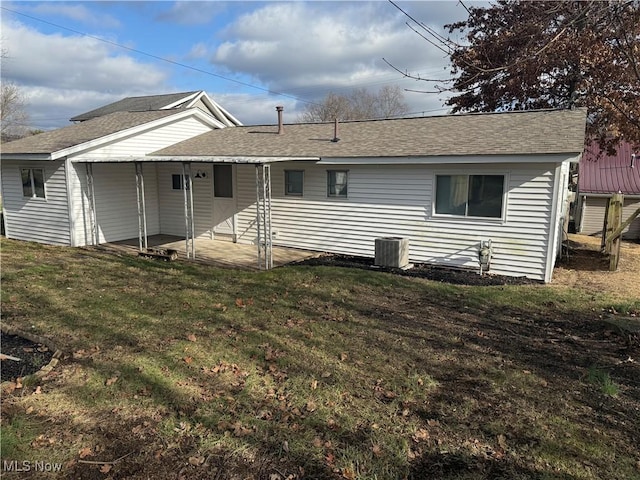 rear view of property with a lawn and central AC