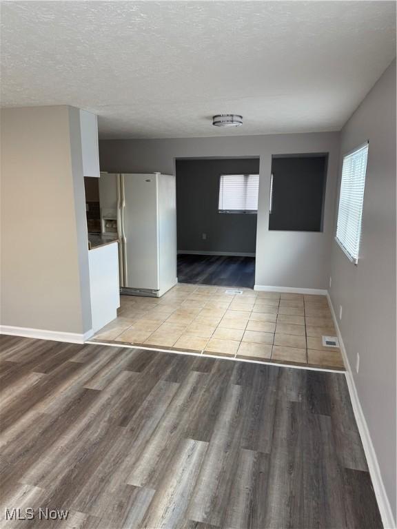 spare room featuring light hardwood / wood-style floors and a textured ceiling