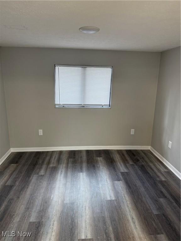 spare room with dark wood-type flooring