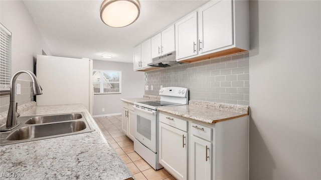 kitchen featuring light tile patterned flooring, under cabinet range hood, a sink, light countertops, and white range with electric stovetop