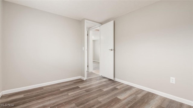 empty room featuring baseboards and wood finished floors