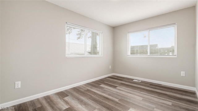 spare room with wood finished floors and baseboards