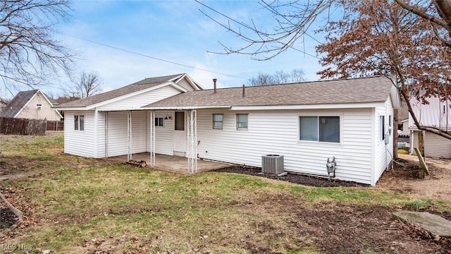 back of house with cooling unit, fence, roof with shingles, a lawn, and a patio area