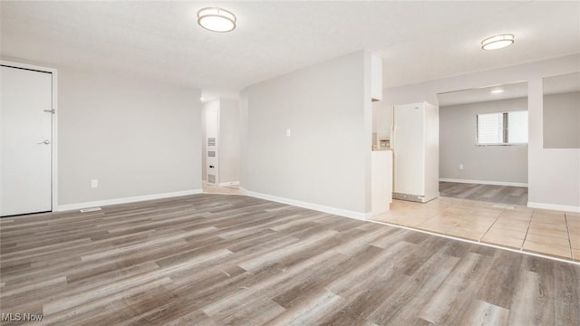 unfurnished room with light wood-style floors and baseboards