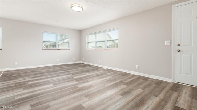 empty room featuring baseboards and wood finished floors