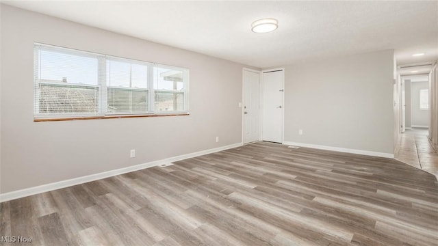 empty room with wood finished floors and baseboards