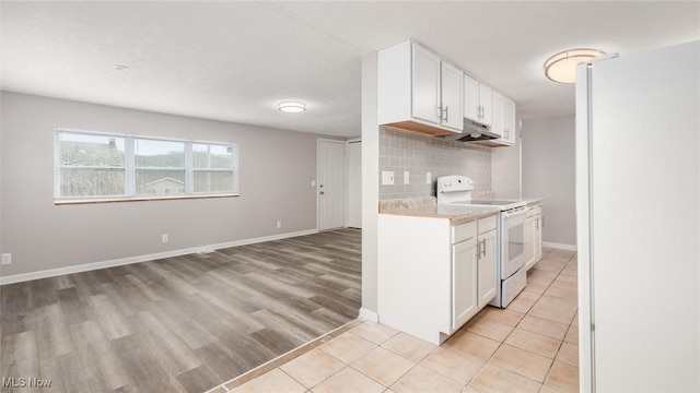 kitchen with light tile patterned floors, white cabinets, electric stove, light countertops, and backsplash