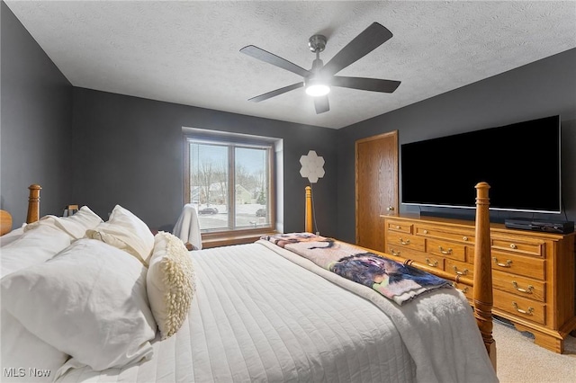 bedroom featuring carpet flooring, a textured ceiling, and ceiling fan