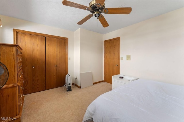 bedroom featuring ceiling fan, a closet, and light carpet