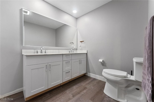 bathroom with vanity, wood-type flooring, and toilet