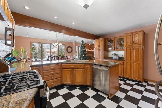 kitchen featuring pendant lighting, an inviting chandelier, sink, kitchen peninsula, and stainless steel appliances