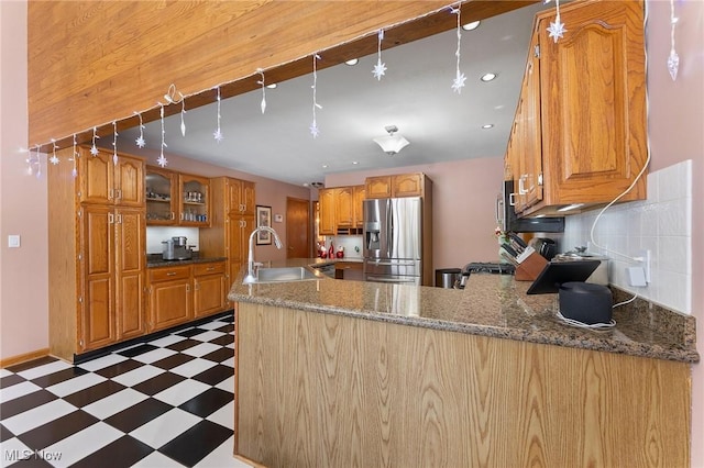 kitchen featuring sink, stainless steel refrigerator with ice dispenser, decorative light fixtures, decorative backsplash, and range