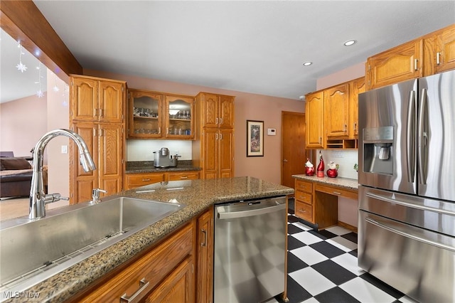 kitchen featuring tasteful backsplash, sink, dark stone counters, and stainless steel appliances