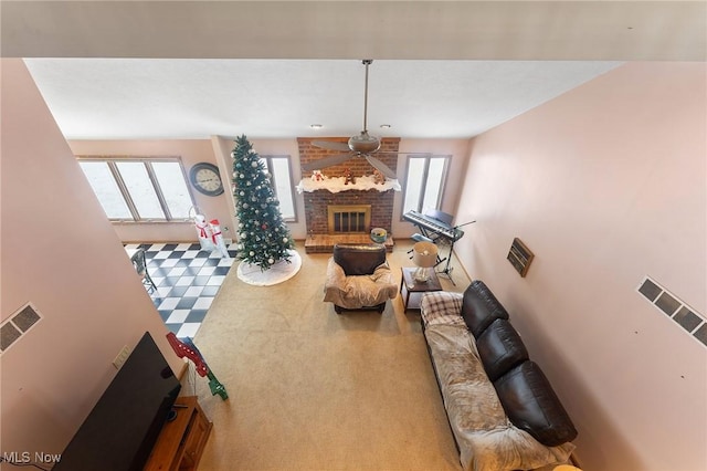 living room featuring carpet, ceiling fan, and a fireplace