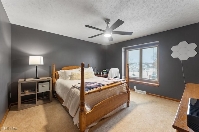 carpeted bedroom featuring a textured ceiling and ceiling fan