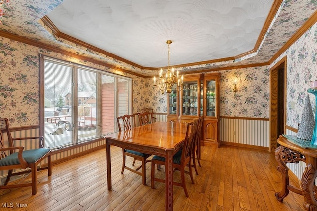 dining area featuring light hardwood / wood-style floors, crown molding, and a chandelier