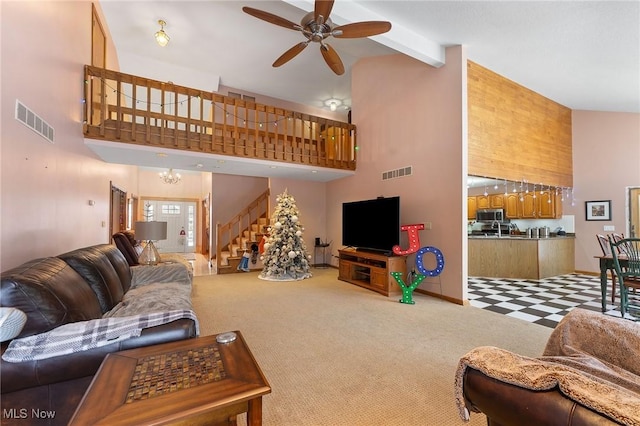 carpeted living room with beam ceiling, high vaulted ceiling, and ceiling fan with notable chandelier