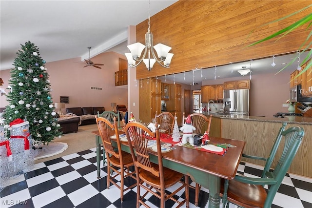 dining space featuring vaulted ceiling with beams, ceiling fan with notable chandelier, and sink