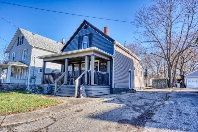 view of front of house featuring an outbuilding, a porch, and a garage