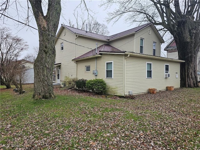 view of side of home with a yard