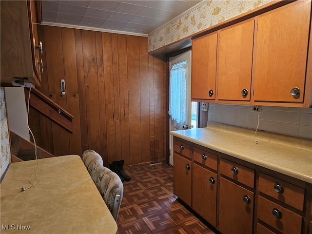 kitchen featuring wooden walls, dark parquet floors, and ornamental molding