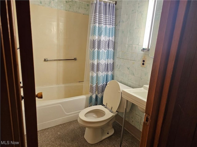 bathroom with toilet, shower / bath combo with shower curtain, and tile walls