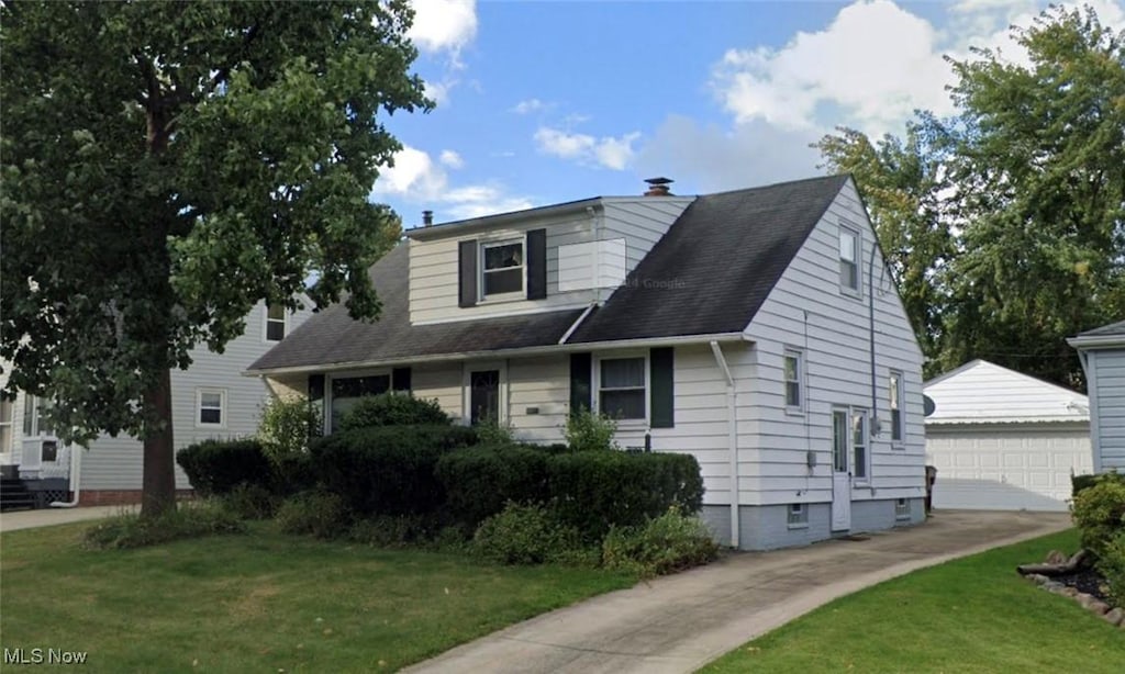 view of front of property with a front yard, a garage, and an outdoor structure